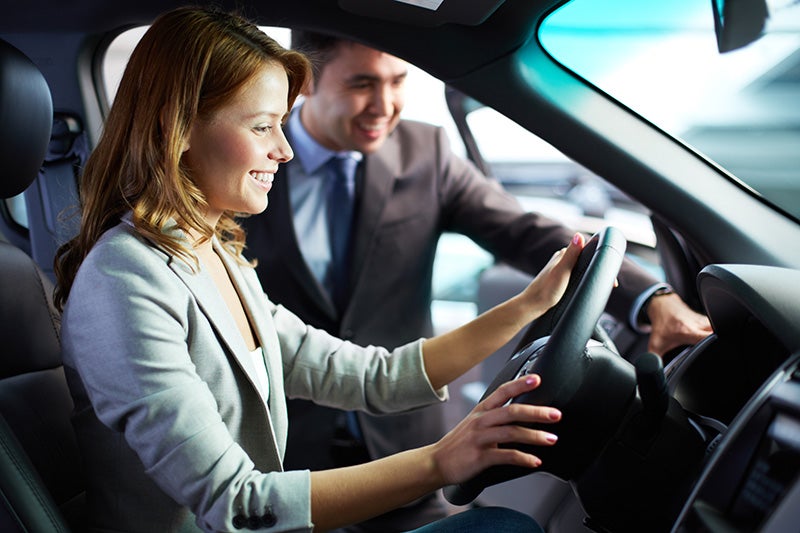 Image of a saleperson and buyer in car